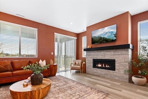 A living room with a fireplace, a sofa, a coffee table, and a television.
