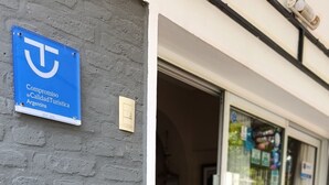 L’entrée d’un hôtel, avec une enseigne bleue, une porte en verre et un mur en briques.