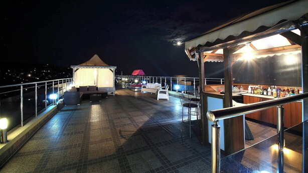 Une terrasse sur le toit comprenant un espace bar, des sièges et une partie abritée.