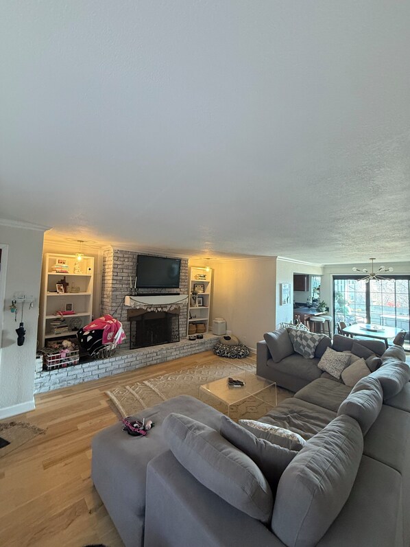 A living room with a fireplace, a sofa, a coffee table, and a television.