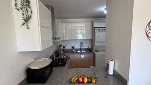 Eine Küche mit Granit Arbeitsplatte, Obstschale und einer hängenden Pflanze.