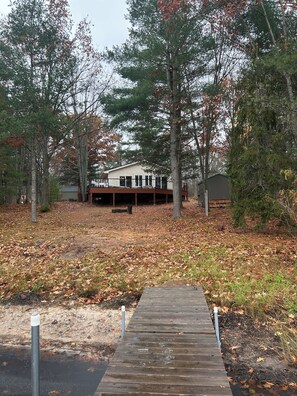 A wooden dock leading to a house surrounded by trees. - Welcome to Blue Gill Serenity!Bring your family to the charming lakeside heaven! (Frederic)