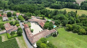 An aerial view of a historic estate with a central courtyard, surrounded by lush greenery and traditional architecture. - LOGIS DU PARADIS (Criteuil-la-Magdeleine)
