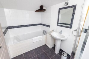 A modern bathroom with a bathtub, a sink, and a glass shower enclosure. - LOGIS DU PARADIS (Criteuil-la-Magdeleine)