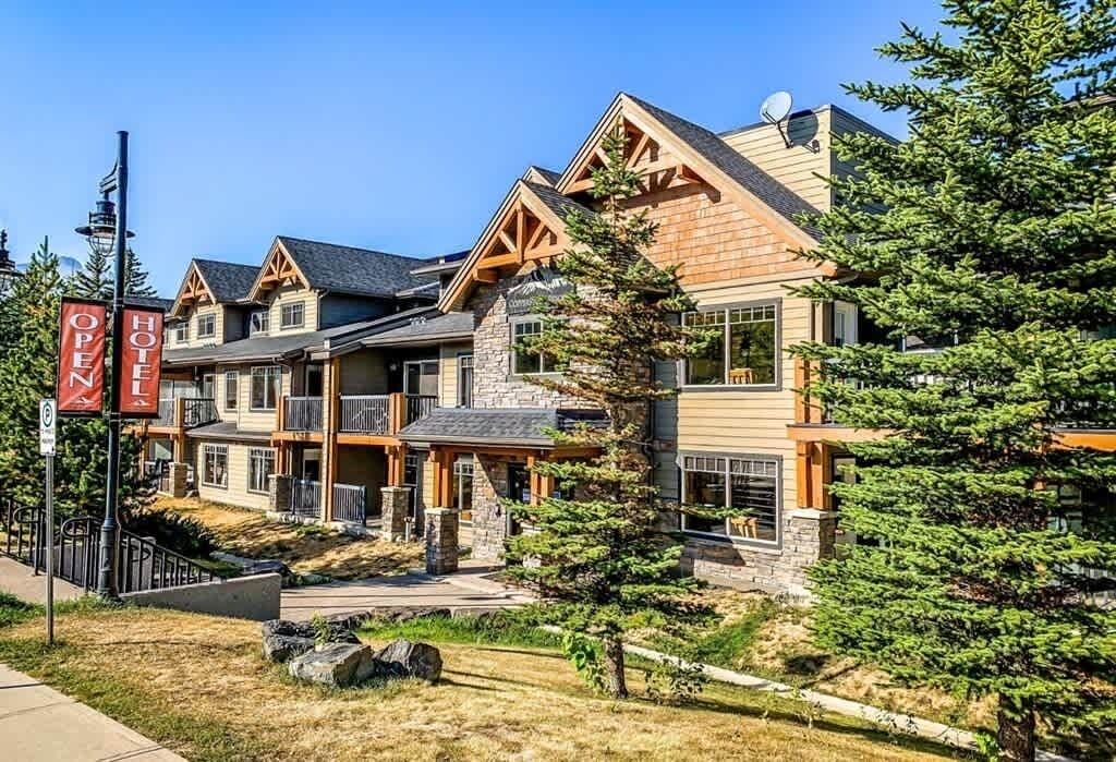 A hotel with a stone facade, multiple balconies, and a clear sky.