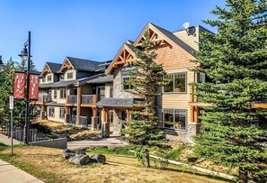 Un hotel con fachada de piedra, varios balcones y cielo despejado.