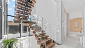 A modern interior with a spiral staircase, large windows, and a minimalist design. - Luxury Villa w/ Heated Pool / Jacuzzi / 6BR /Games/ Miami (Miami)