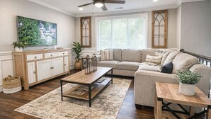 A living room with a sofa, coffee table, TV, and a cabinet. - Groups Welcome-Sleeps 20-Pets OK-Fire Pit-BBQ (Charlotte)