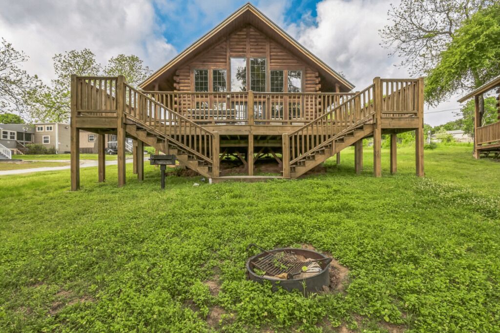 Une cabane en bois dotée d’une terrasse et d’un escalier menant à un balcon.