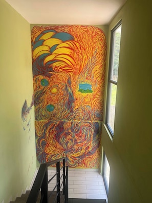 Un escalier orné d’une fresque murale aux couleurs vives.
