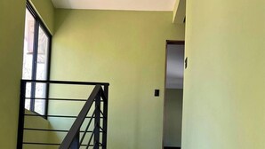 Uma escada com corrimão preto que dá para um patamar.