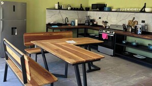 Cozinha moderna com área de jantar, incluindo um banco, geladeira e fogão.