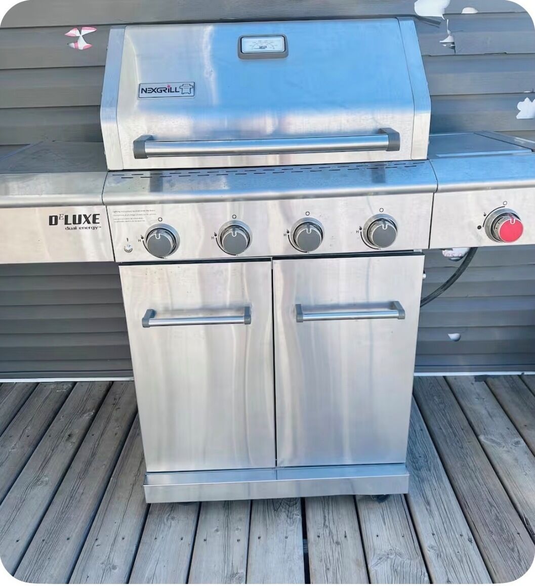 A stainless steel outdoor grill with a control panel and dual energy feature.