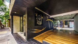 A modern building with a black and white exterior, a wooden bench, and a sign that reads 'A Perfect Place.' - Perfect Place 211 | Studio, Rooftop Pool & Gym (Playa del Carmen)