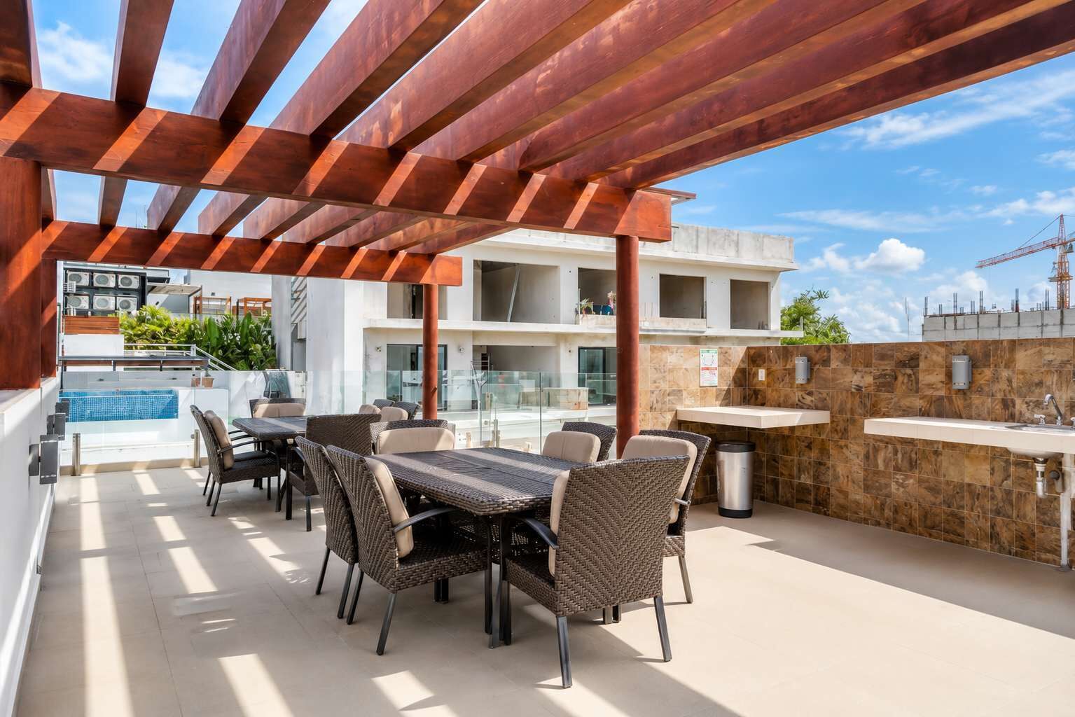 Un patio al aire libre con piscina, zona de comedor y pared de piedra.
