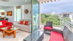 Ein modernes Wohnzimmer mit einer Couch, einem Couchtisch und einem Balkon mit Sitzgelegenheit.
