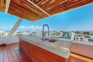 A rooftop terrace with a concrete countertop, a sink, and a wooden ceiling. - Playa del Carmen Condo: Rooftop Pool & Ocean View (Playa del Carmen)
