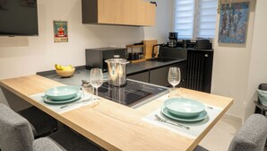 Eine moderne Küche mit einer zentralen Kochinsel, schwarzen Geräten und einem Holzschrank darüber.