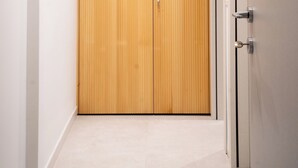 Ein Flur mit einem hölzernen Kleiderschrank und einer Tür mit Griff.