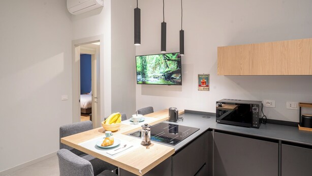 Eine moderne Küche mit Flachbildfernseher, Mikrowelle und Kaffeemaschine.