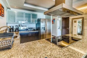 Eine moderne Küche mit Granit-Arbeitsplatten, Edelstahlgeräten und einer zentralen Kochinsel.
