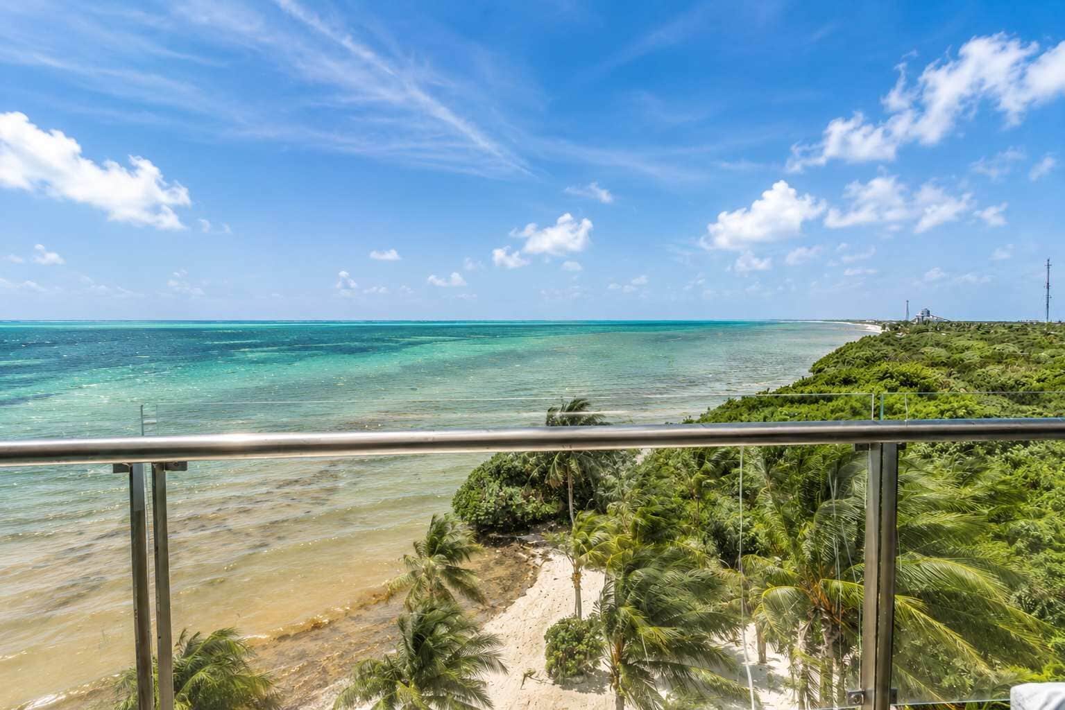 Une plage tropicale avec une eau turquoise et limpide, un rivage sablonneux et une végétation luxuriante.