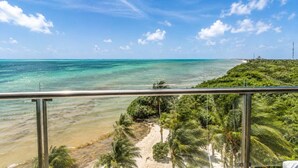 Une plage tropicale avec une eau turquoise et limpide, un rivage sablonneux et une végétation luxuriante.