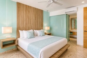 A modern hotel room with a large bed, wooden headboard, two bedside tables with lamps, a ceiling fan, and an air conditioning unit. - Modern Playa del Carmen Apt: Rooftop Pool & WiFi (Playa del Carmen)