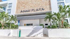 Un bâtiment avec une enseigne indiquant « ANAH PLAYA » et une entrée couverte avec des marches.