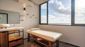 A modern bathroom with a large window, a wooden bench, a vanity with a mirror, and a sink. - Oceanfront 2BR, Rooftop Pool, Gym, Walk to Beach (Playa del Carmen)