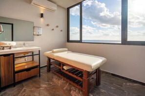 Ein modernes Badezimmer mit einem großen Fenster, einer Holzbank, einem Waschtisch mit Spiegel und einem Waschbecken.