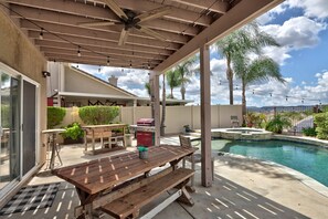 A covered outdoor area with a pool, a wooden table, and a grill. - Palm Tree Lane Retreat in Murrieta: Private Pool, Spa, Loft, Balcony, Ideal Mid-Term Stay +Solar EV! (Murrieta)
