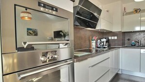 Eine moderne Küche mit Edelstahlgeräten, weißen Schränken und einem eingebauten Backofen.