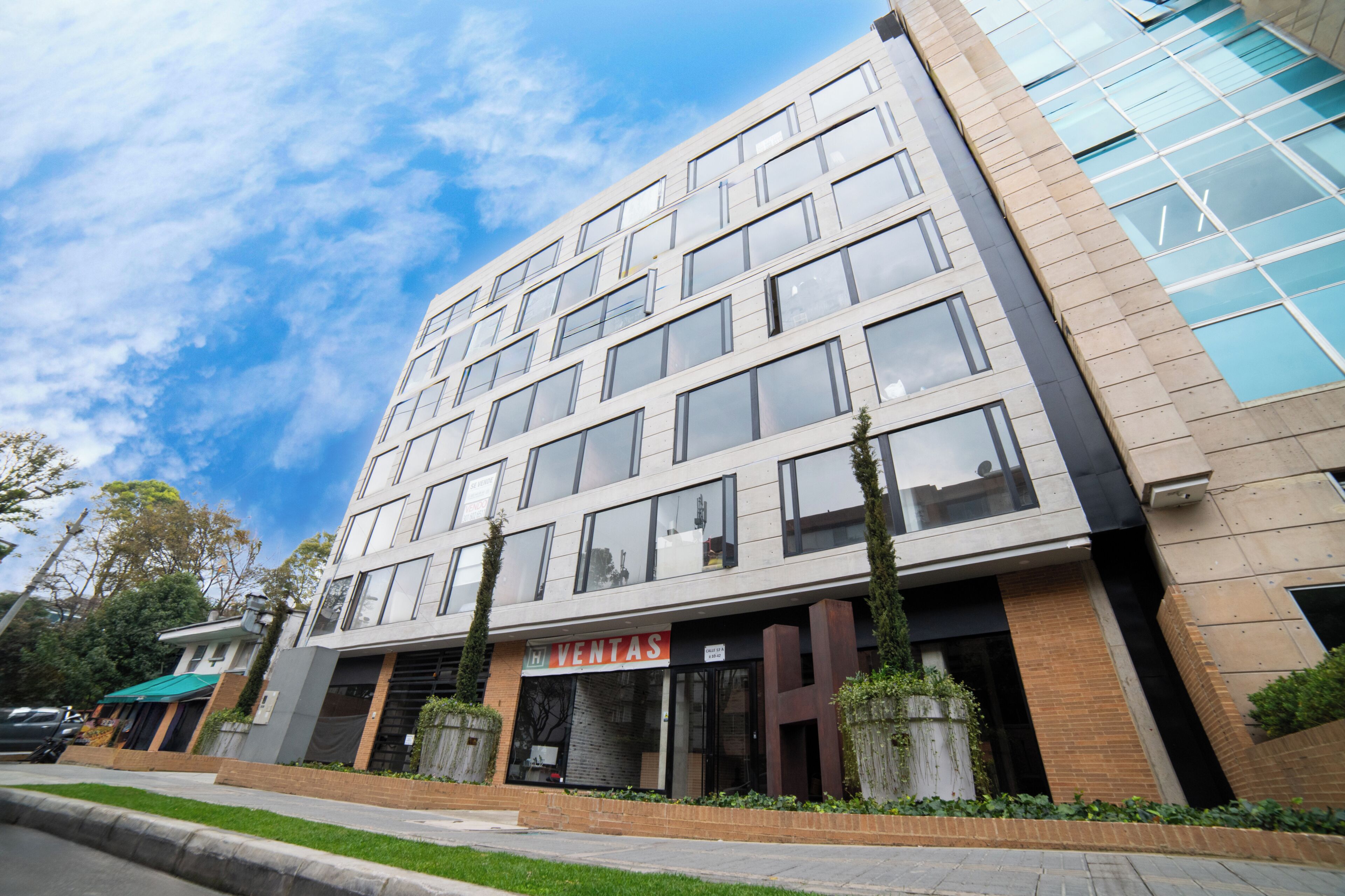 Un edificio de varios pisos con una fachada comercial que dice 'VENTAS' en la planta baja.