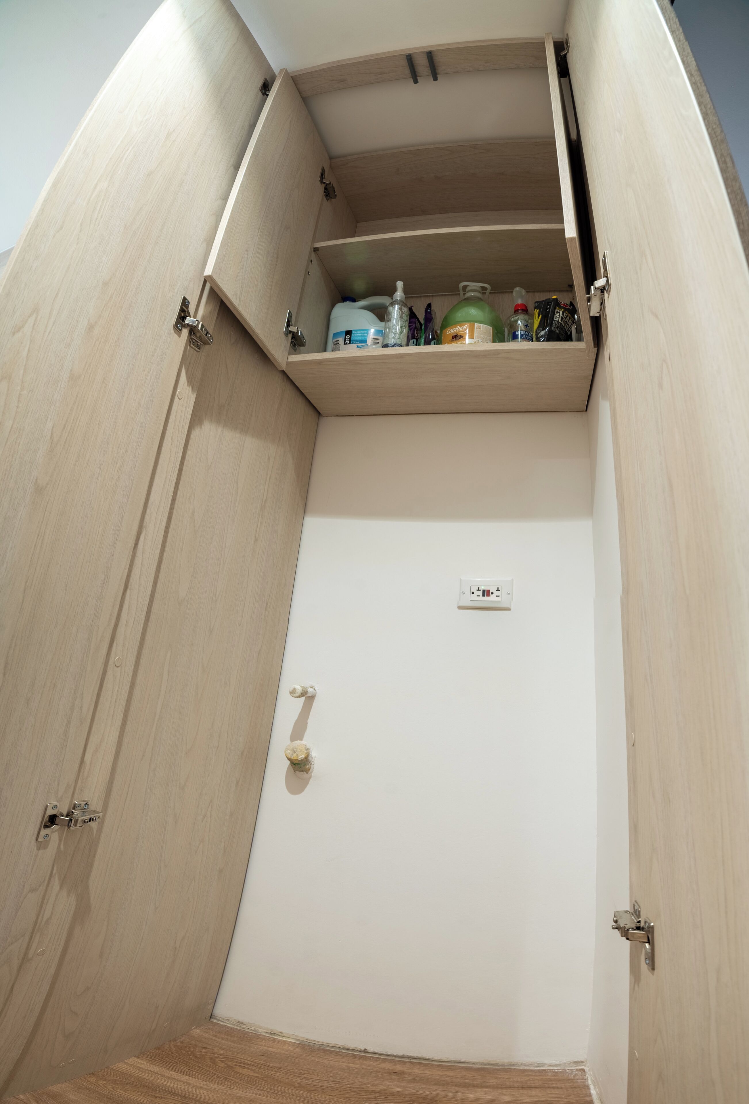 Un armario de madera con un estante que contiene varios objetos.
