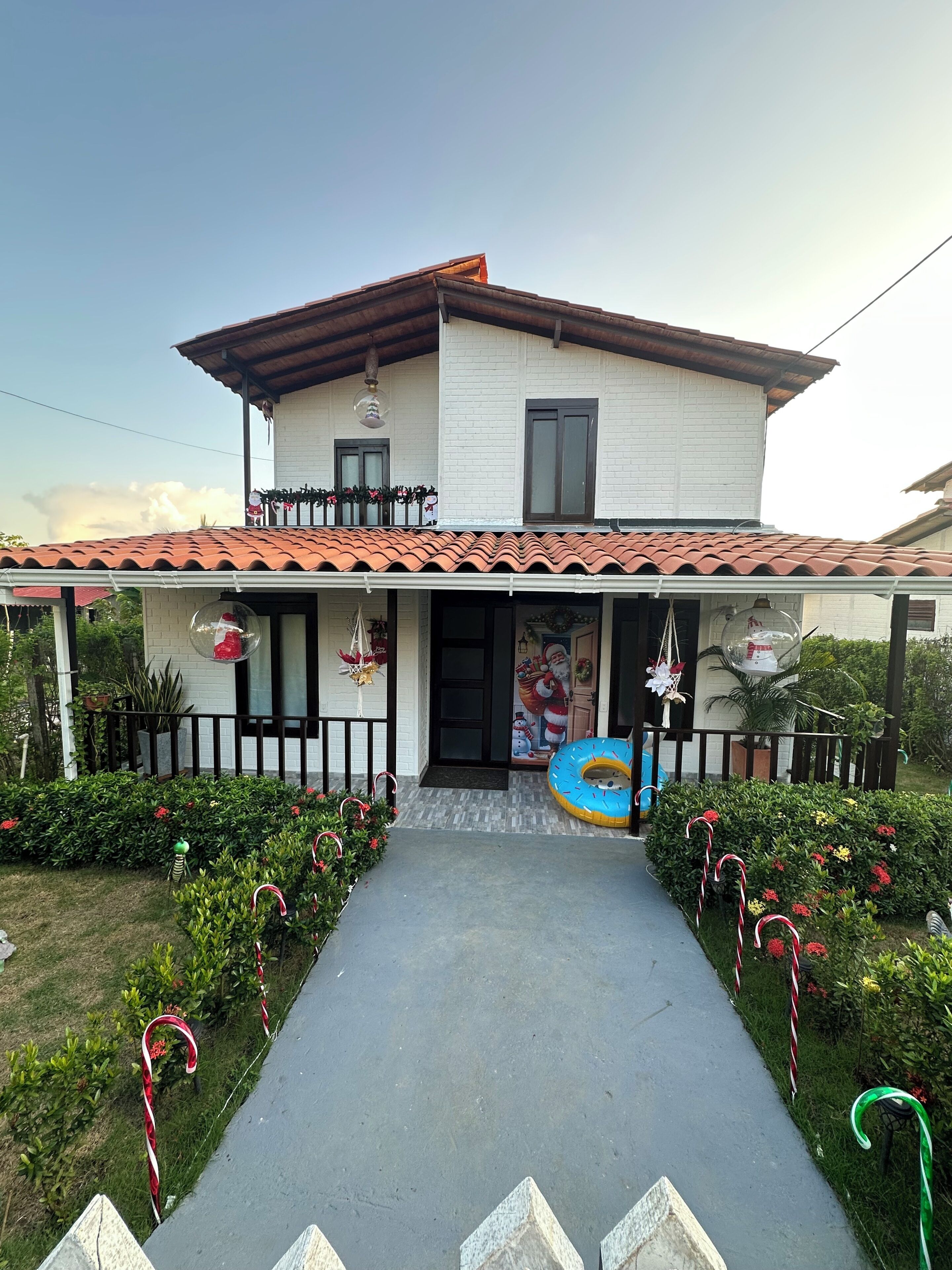 Une maison à deux étages, avec un toit en tuiles, un balcon et une porte d’entrée.