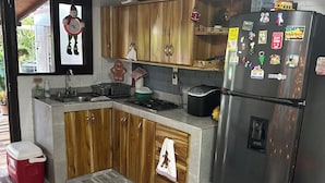Une cuisine moderne avec des meubles en bois, un réfrigérateur en acier inoxydable et un four encastré.