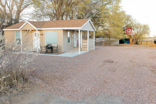 A small, single-story building with a porch and a fenced yard.