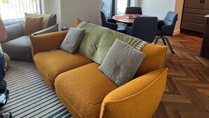 A living room with a sofa, chairs, a dining table, and a kitchen area. - 2-bedroom apartment in lovely London with air conditioning (London)