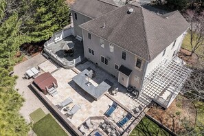 A large house with a patio, outdoor seating, and a swimming pool. - Hoppy Place: 066-M Expansive Deck area, Hot Tub, Walk to Salt Water (Mashpee)