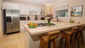 A kitchen with a central island, bar stools, a refrigerator, and a painting on the wall. - Cartagena Beach Front
You will be Living the life on the beach (Cartagena)