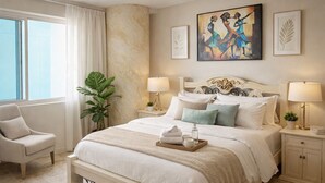 A hotel room with a large bed, two bedside tables, a chair, a potted plant, and artwork on the walls. - Cartagena Beach Front
You will be Living the life on the beach (Cartagena)