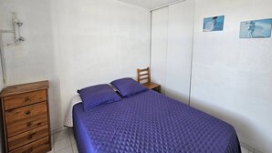 Ein Schlafzimmer mit einem Bett, einer Holzkommode und zwei Bildern an der Wand.