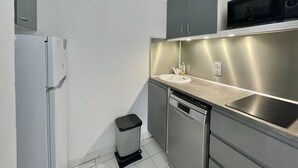 A compact kitchen with a refrigerator, microwave, sink, and dishwasher. - CAP D'AGDE - Plage Richelieu / Réf 193 (CAP D'AGDE)