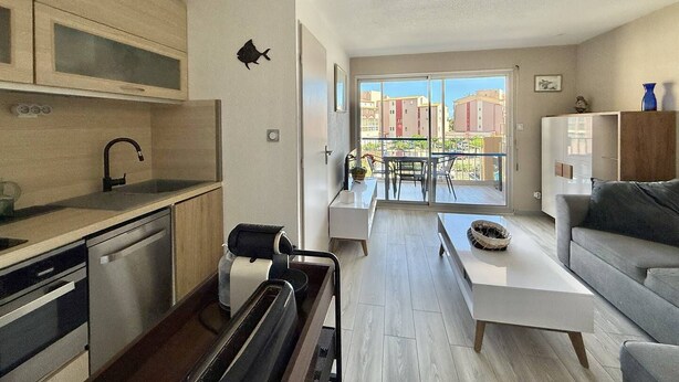 Een modern appartement met keuken, eetgedeelte en woonkamer.