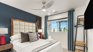 Habitación de hotel moderna con una cama grande, ventilador de techo, lámparas de noche, una ventana con cortinas y un estante de madera.