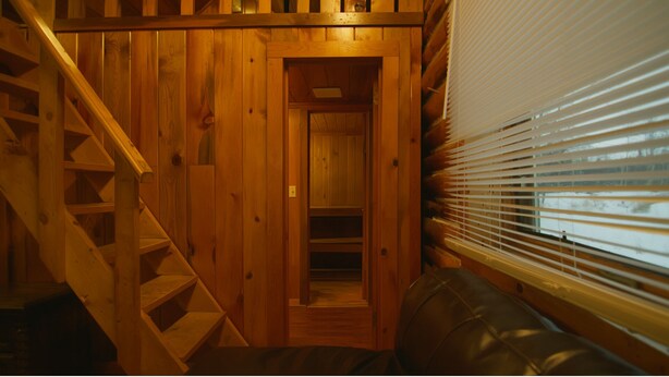 A wooden staircase leading to a door, a bench, and a window with blinds. - Alaska Homestead Roadhouse (Delta Junction)