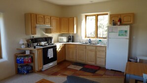 Una cocina compacta con gabinetes de madera, estufa, microondas y refrigerador.