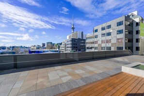 Une terrasse sur le toit offrant une vue sur les toits de la ville, notamment sur une tour imposante.