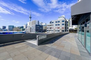 A rooftop terrace with a city skyline view, including a prominent tower. - Modern 2-Bedroom Apartment Near Ponsonby & CBD (Auckland City)